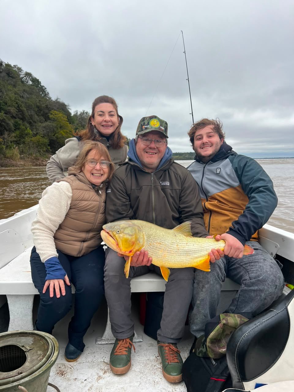 Familia con un dorado durante una jornada de pesca en Villa Urquiza Entre Ríos
