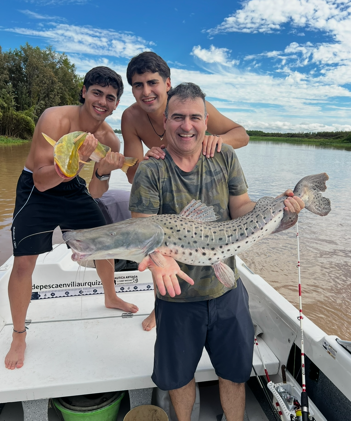 Padre e hijos pescando un surubí en el río Paraná